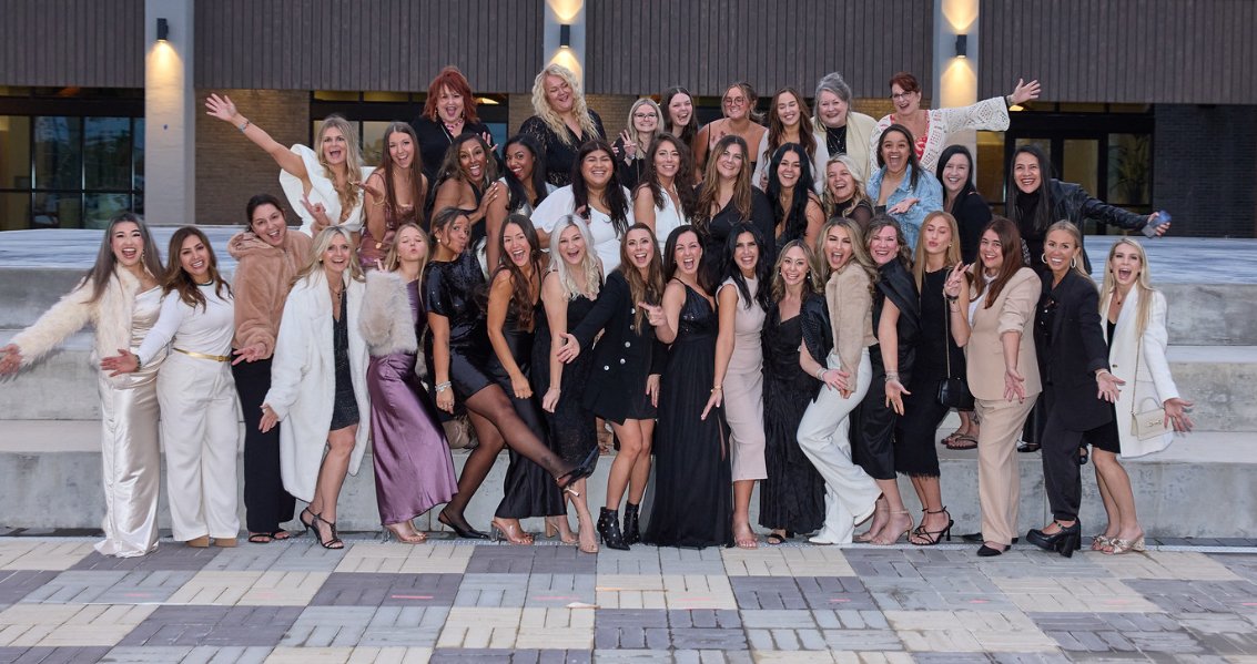 Team dressed up on stairs at an evening event